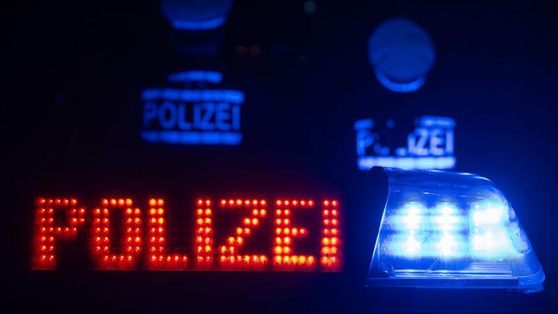 Bundespolizei ermittelt gegen aggressive St.-Pauli-Fußballfans Zwei Polizisten stehen vor einem Streifenwagen.