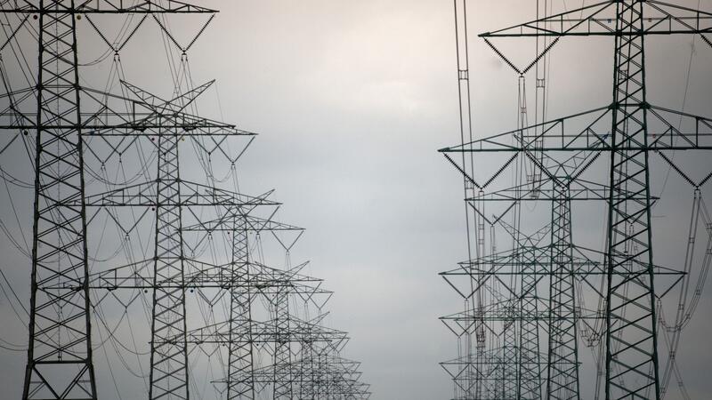 Zwei Reihen von Hochspannungsmasten bei Brokdorf.