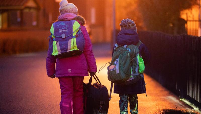Hochwasser und Bauern-Demos beeinträchtigen Schulstart Zwei Schüler gehen am frühen Morgen auf dem Schulweg zu ihrer Grundschule in der Region Hannover.