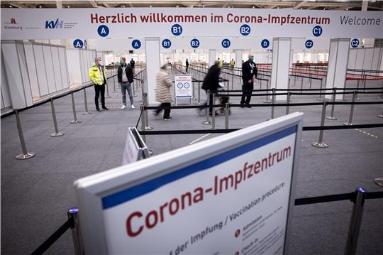 Zwei Senioren sind im Eingangsbereich des Corona-Impfzentrums in den Hamburger Messehallen auf dem Weg zur Impfung. Foto: Charisius/dpa