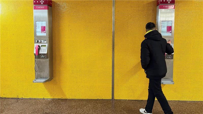 Zwei Wandtelefone am Bochumer Hauptbahnhof - mancher Passant bleibt stehen und blickt verwundert auf die alte Technik.