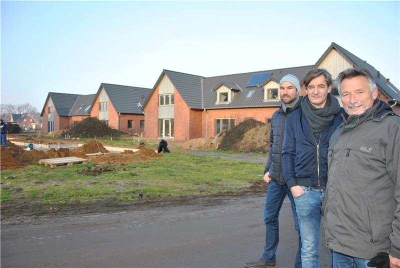 Zwei der Dreierhäuser (hinten) und das Doppelhaus (links, nicht im Bild) sind fertig, das dritte Dreierhaus wird gerade gebaut: Klaus Kühnel als Vertreter der Bauherrengemeinschaft, Architekt Carsten Wolf und Bauleiter Torsten Pape (von rec