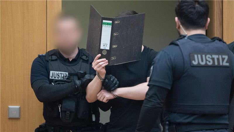 Zwei der Männer verdeckten beim Betreten des Gerichtssaals ihr Gesicht.