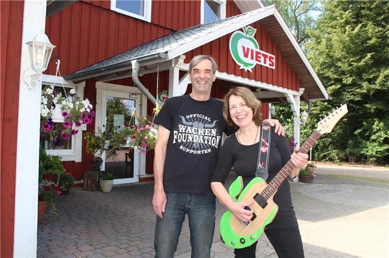 Zwei eingefleischte Hardrock-Fans sind mit 66 Jahren wieder voll in der Szene zugange: Claus Viets und seine Frau Barbara mit ihrer eigens für Wacken gebauten Apfel-Gitarre vor ihrem Obsthof in Rade-Mienenbüttel. Sein Hof-Logo, das in seine