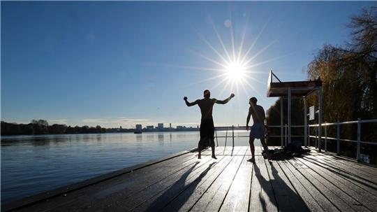 Zwei junge Männer haben Spaß beim Eisbaden in Hamburg an der Alster.