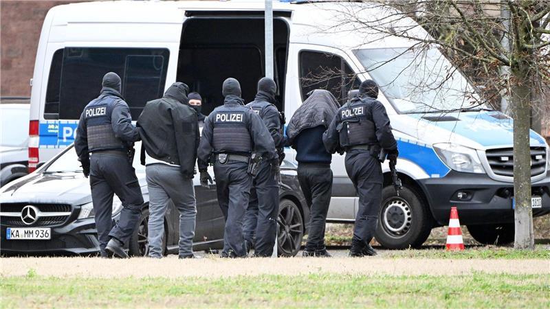 Zwei mutmaßliche Hamas-Mitglieder werden von Polizisten bei einem Hubschrauberlandeplatz von einem Hubschrauber zu einem Auto geführt. (Archivbild)