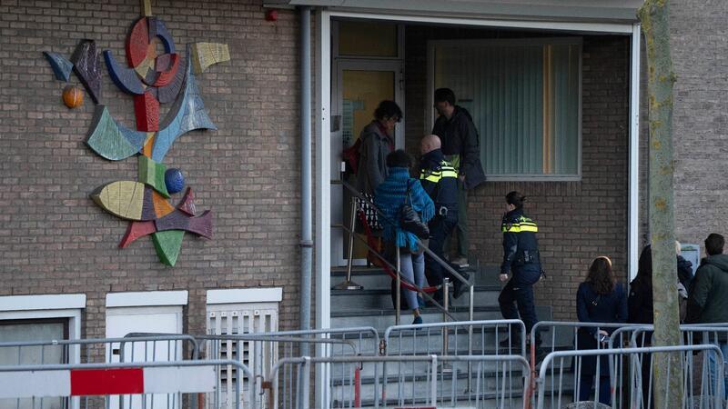 Neun Männer wegen Mordes an Kriminalreporter vor Gericht Zwei niederländische Polizeibeamte betreten das Hochsicherheitsgebäude des Gerichts.