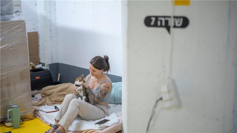 Zwischen Alltag und Alarm - Katze und Frau suchen während eines Raketenangriffs Zuflucht im Parkhaus