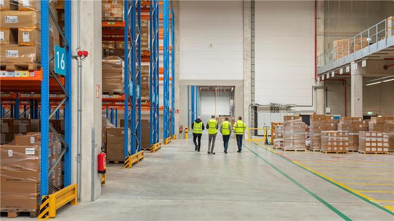 Zwischen hohen Regalreihen und weiten Gängen zeigt sich die Dimension moderner Logistik.