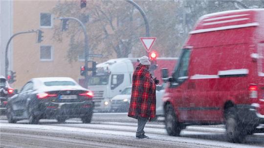 Zwischen wartenden Autos an der Ampfel: Bitten um Almosen bei Schneetreiben in Hamburg.