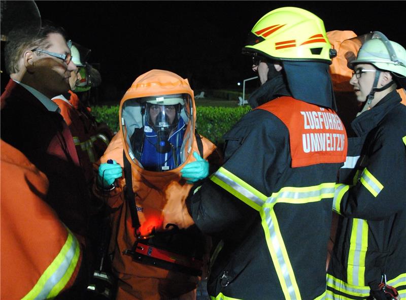<p>Chemikalienschutzanzug-Träger der Feuerwehr werden vor dem Stader Freibad mit Messgeräte ausgestattet. Foto Vasel</p>