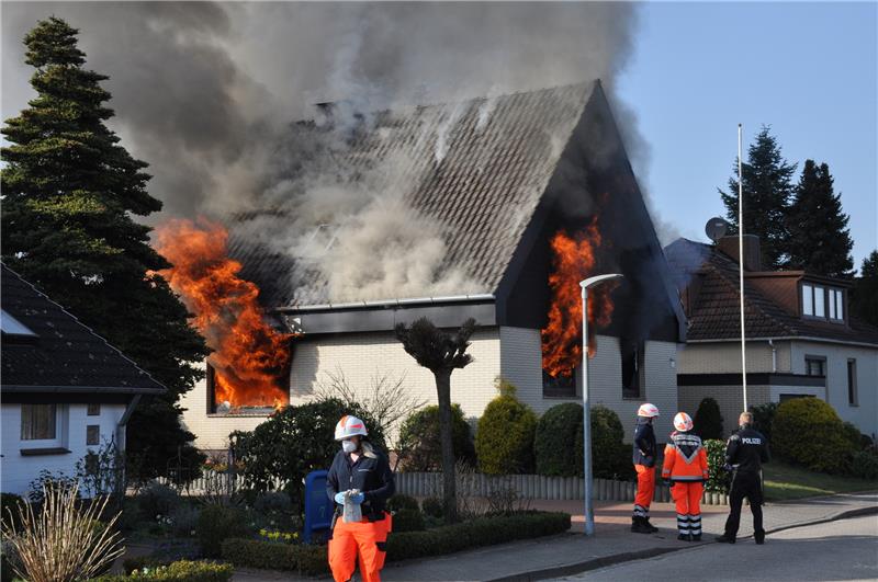 <p>Kurz vor dem Eintreffen der Feuerwehr – erste Einsatzkräfte von Polizei und Rettungsdienst sind bereits vor Ort – schlagen Flammen aus den Fenstern des Hauses in der Kiefernstraße. Foto: Schmidt</p>