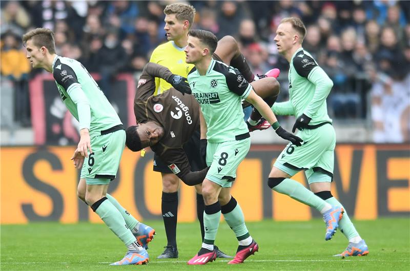 Hürzeler-Premiere und Debatte um VAR: St. Pauli siegt gegen Hannover 96 <strong> St. Paulis Oladapo Afolayan (Mitte) im Zweikampf mit Hannovers Enzo Leopold (2.v.re.). Foto: Michael Schwartz/dpa</strong>